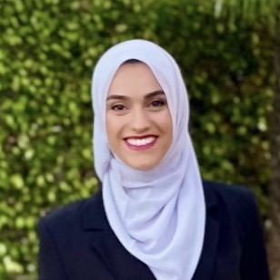 Headshot of Thabat Dahdoul. A woman with wearing light purple hijab with a smile and dark pink lipstick.